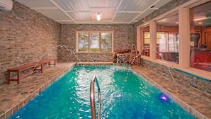 Ein Hallenbad mit einer Holzbank und einer Steinwand.