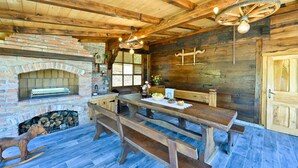 Un intérieur rustique avec des éléments en bois, une cheminée en briques, des bancs en bois et une table à manger.