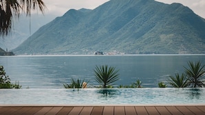 Una piscina con vista su un lago e montagne sullo sfondo.