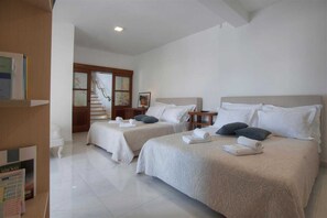 A hotel room with two beds, a staircase, and a view of the outside.