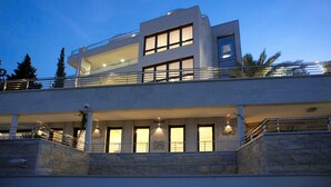 A modern multi-story building with a flat roof, large windows, and a balcony. - Alexandar Suits & Spa 401 (Budva)