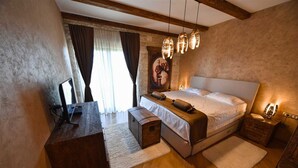 A bedroom with a wooden bed, a desk, a chair, and a nightstand. - Classic  Estate  Villa (Kotor)