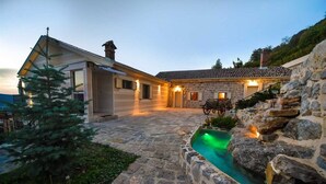A stone house with a stone pool, a waterfall, and a bench. - Classic  Estate  Villa (Kotor)