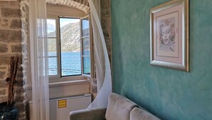 Ein Zimmer mit Meerblick, ein gerahmtes Bild an der Wand und ein Sofa.