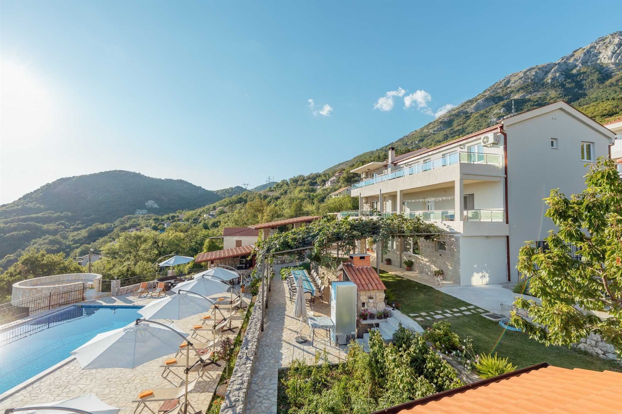 A resort with a pool, outdoor seating, and a view of the mountains.