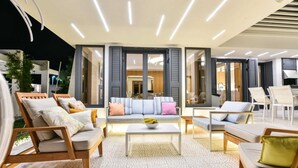 A modern living room with a sofa set, a coffee table, and a dining area with chairs. - Dulcinea  Dream  Villa (Ulcinj)