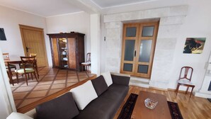 A living room with a sofa, a coffee table, and a dining area with chairs and a cabinet. - Villa Rustica Mediteranea (Budva)