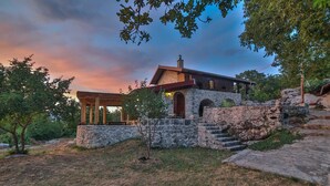 A stone house with a wooden porch and a stone staircase leading to the entrance. - Royal Villa Ana - 2 Bedroom Villa (Cetinje)