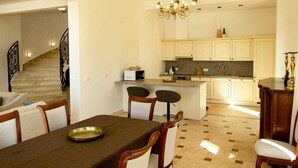 A dining area with a table, chairs, and a chandelier. - Oak Leaf Residence Villa 1 (Budva)