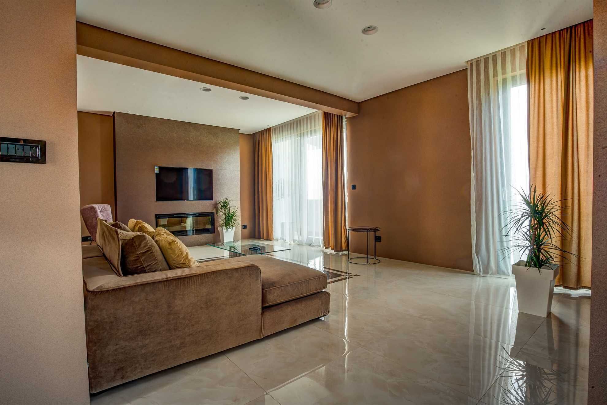 A modern living room with a sofa, TV, and a glass coffee table.