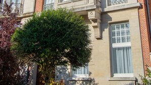 A multi-story building with a classical architectural style, featuring a symmetrical facade, large windows, and decorative stonework. - The Old Beech (Antwerp)