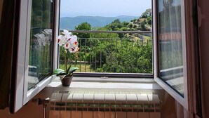 A room with a window overlooking a scenic landscape. - Villa Charming Vineyard (Budva)