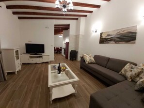 A living room with a television, sofa, and coffee table.