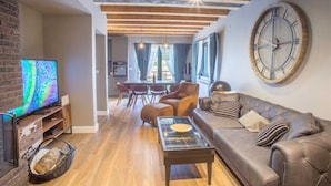 A modern living room with a leather sofa, a glass coffee table, and a large wall clock. - Authentic Mountainside Villa Lusso (Zabljak)