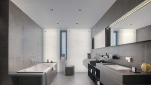 A modern bathroom with a large bathtub, two sinks, and a large mirror. - Villa Geba Suite Elena (Budva)