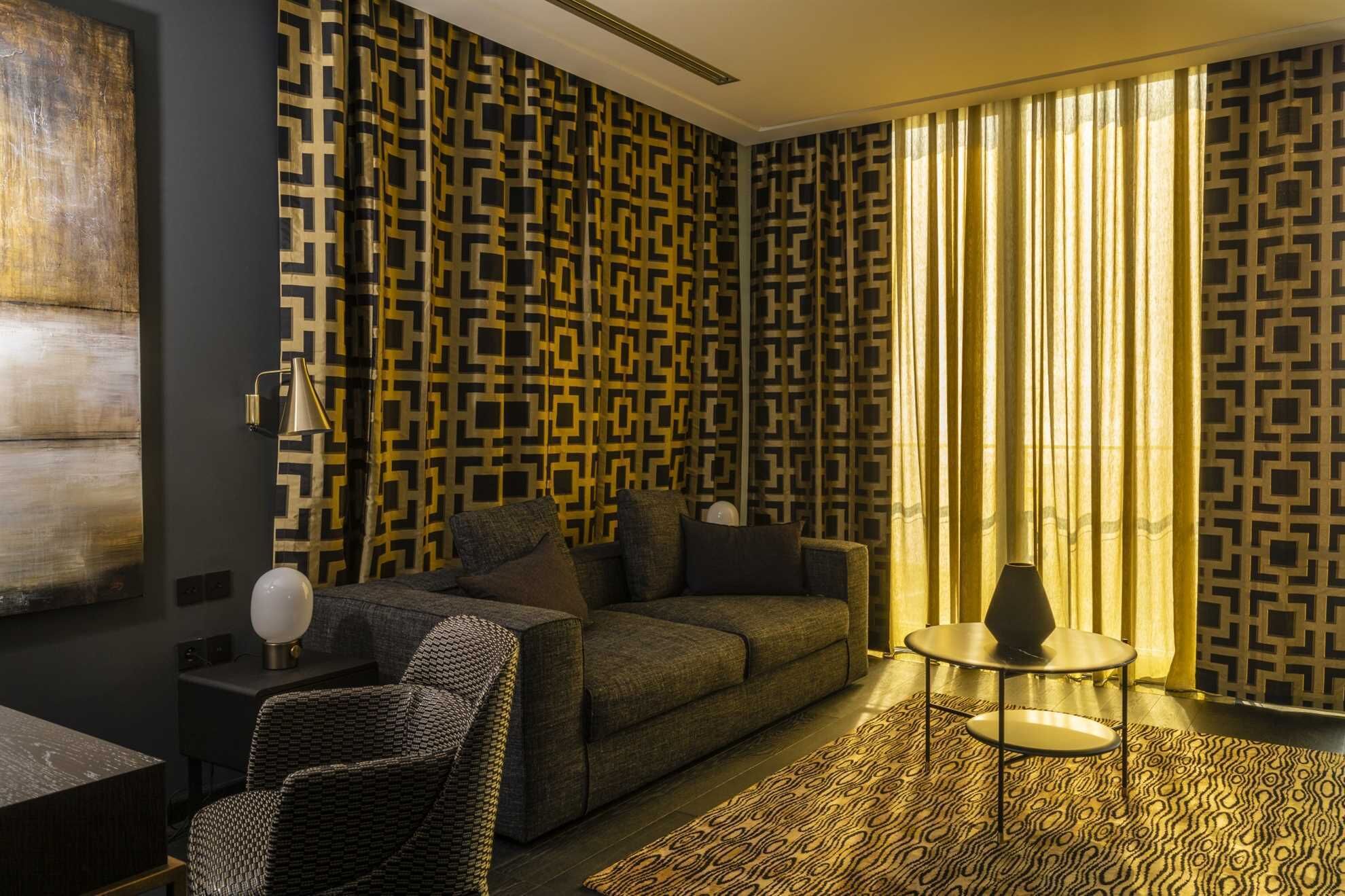 A modern living room with patterned wallpaper, a sofa, a coffee table, and a rug.