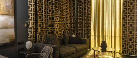 A modern living room with patterned wallpaper, a sofa, a coffee table, and a rug.