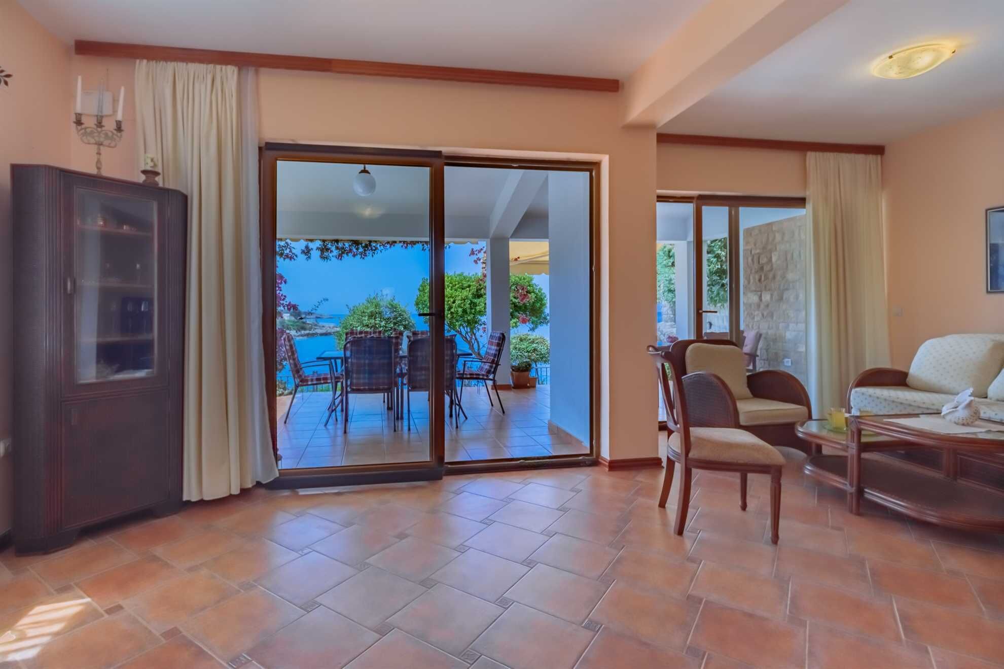 A spacious living area with a sliding glass door leading to a balcony with outdoor furniture.
