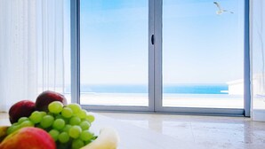 A room with a large sliding glass door leading to a balcony with a view of the sea. - Luxury Seaview Villa Krimovica 2 (Budva)