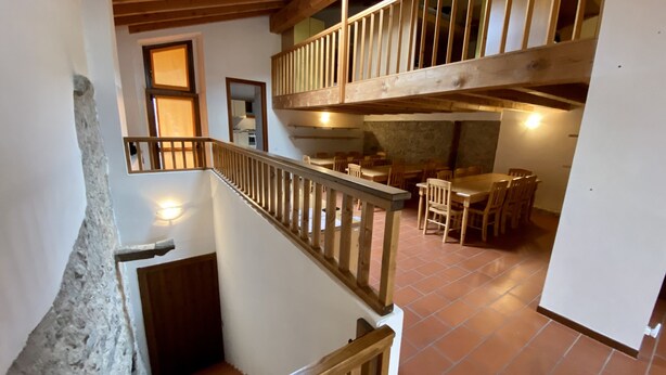Un interno in legno su più livelli, con una scala, zona pranzo e cucina.