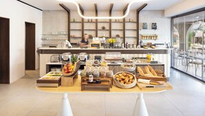 A buffet setup with various food items and a coffee station in a modern interior. - Son de Mar (Lecci)