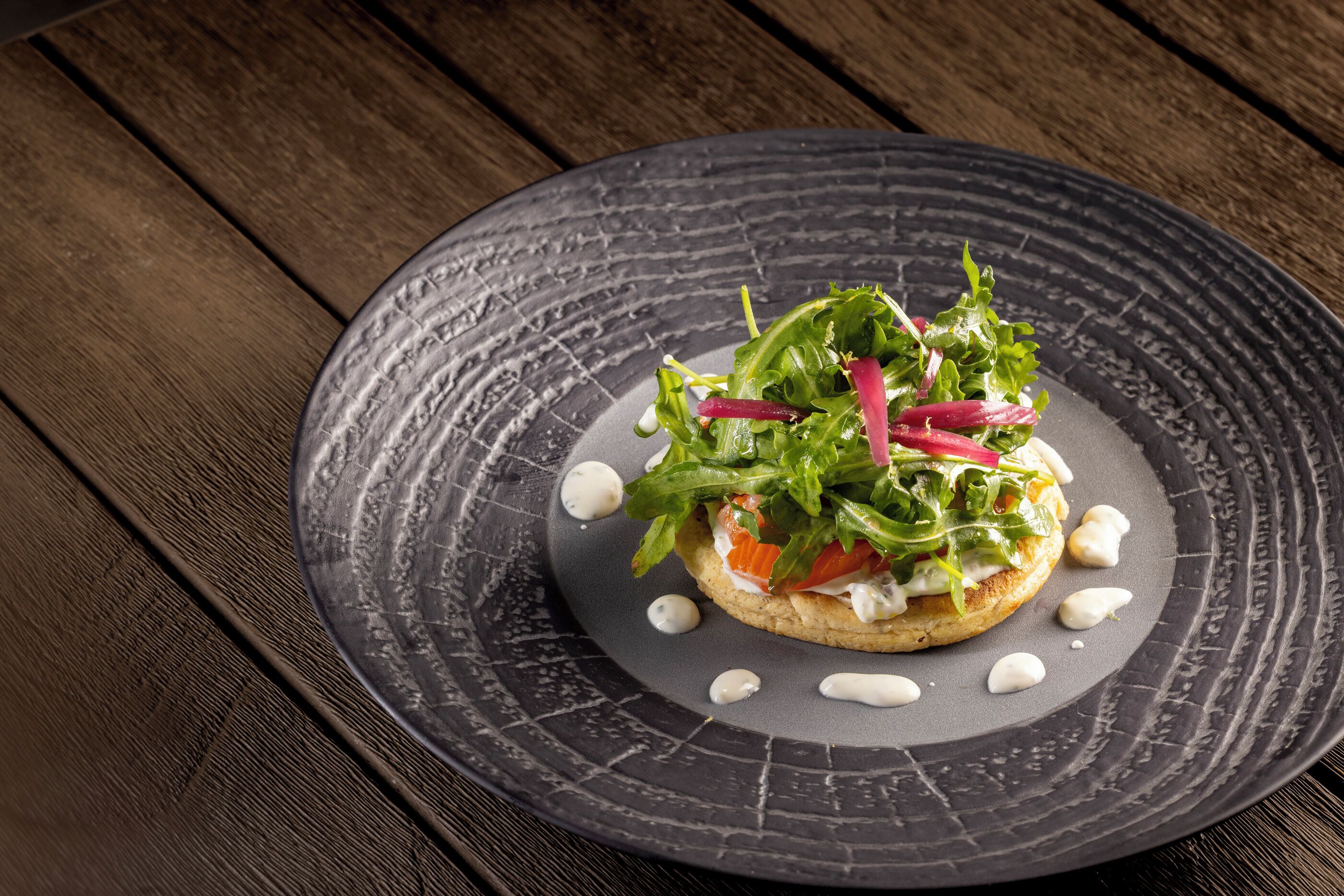 A plate with a salad on a textured plate.
