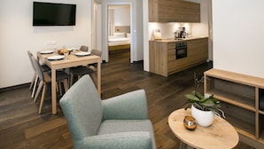 Un espace de vie moderne comprenant un coin repas, une cuisine et une chambre.
