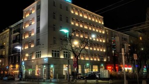 A multi-story hotel with illuminated windows and a neon sign on the top floor.