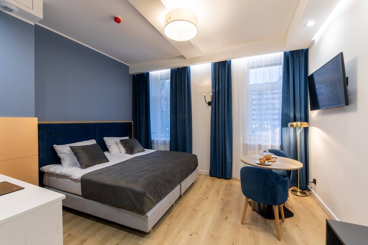 Una habitación de hotel moderna con una cama, un escritorio, una silla y un televisor.