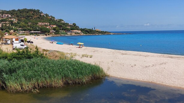A beach with clear water, a sandy shore, and a hillside with buildings. - Charming villa 50 m from the sea. Pets allowed (conca)