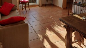 A living room with a sofa, a chair, a table, and a TV mounted on the wall. - Charming villa 50 m from the sea. Pets allowed (conca)