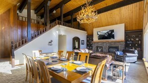 A spacious living area with a fireplace, a dining table set for four, and a staircase leading to an upper level. - Hot Tub, Ski Wolf Creek, Fish San Juan River Village (Pagosa Springs)