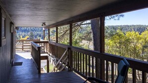A wooden deck with a railing, overlooking a forested area with trees and a mountain in the distance. - Hot Tub, Ski Wolf Creek, Fish San Juan River Village (Pagosa Springs)