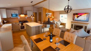 Una cucina moderna con zona pranzo, camino e televisione.