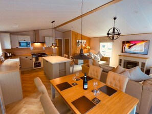 Una cocina moderna con comedor, chimenea y televisor.