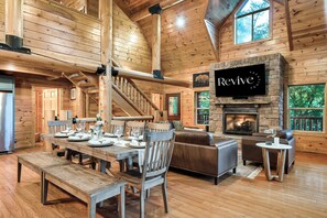 A wooden interior with a dining area, a fireplace, and a stone fireplace. - Secluded|5 Min to Twn|Game Rm|Kid-Friendly Escape (Pigeon Forge)