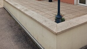 Un bâtiment avec une cheminée en briques, un pot de fleurs et un lampadaire.