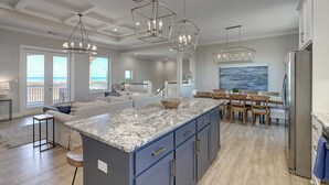 A spacious kitchen with a large island, pendant lighting, and a view to the outside. - Secluded beachfront subdivision with a boardwalk to the beach, private pool! (Port Aransas)