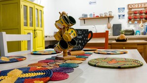 Una mesa con individuales tejidos de colores y una pila de tazas.