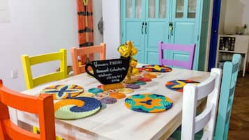 A dining table with colorful woven placemats, a sign with a username and password, and a yellow decorative item.