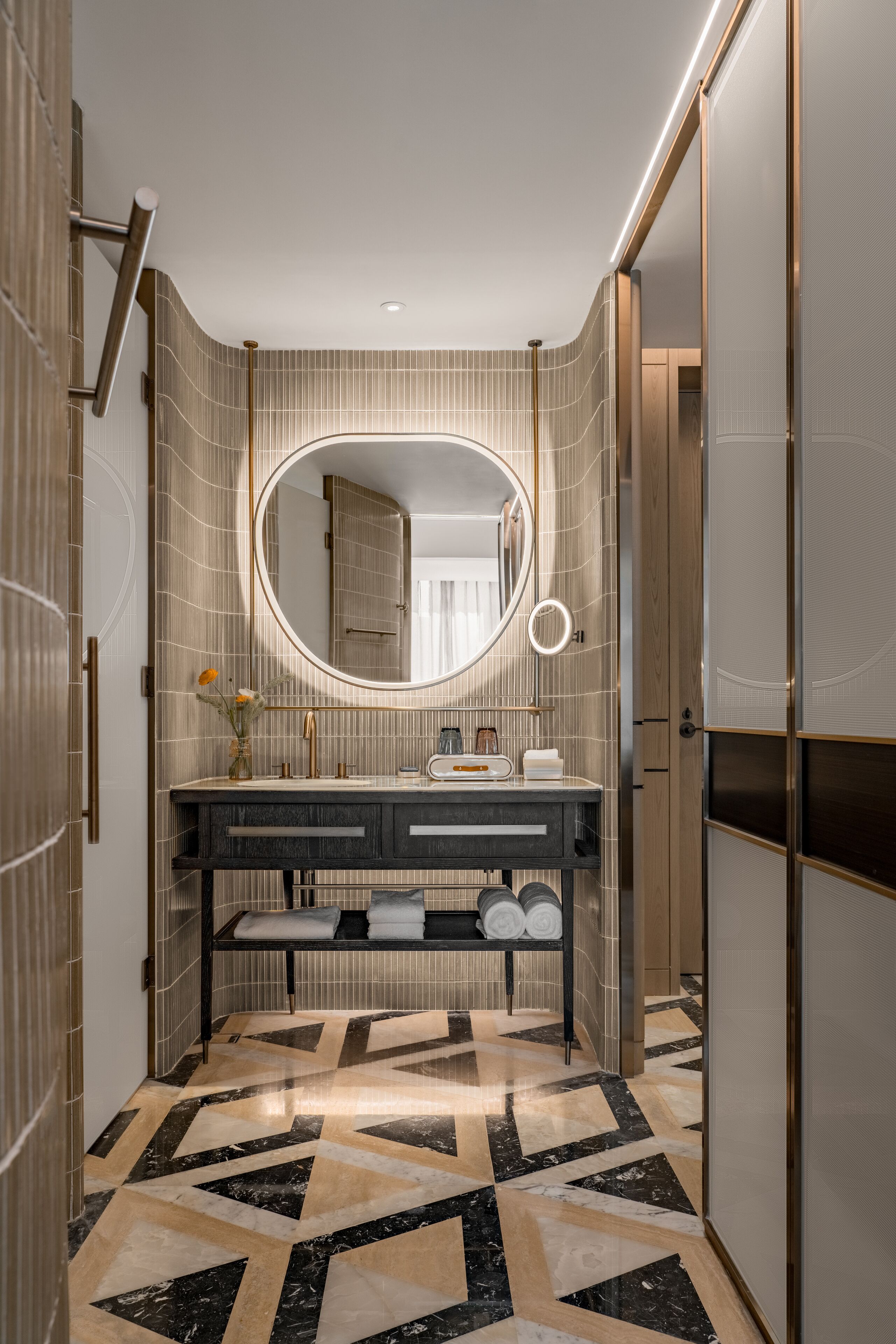 A modern bathroom with a vanity, a large mirror, and a patterned floor.