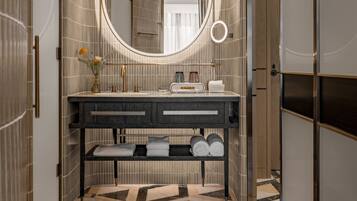 A modern bathroom with a vanity, a large mirror, and a patterned floor.