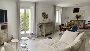 A modern living room with a sofa, a dining table, and a TV. - House La Luberonne Gordes Vaucluse Provence. Heated pool from May 15. (Gordes)