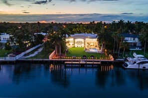 A waterfront property with a pool, a well-maintained lawn, and a large house with a circular driveway. - 8500sf Intracoastal Mansion/Cinema/Dock/Pool (Hollywood)