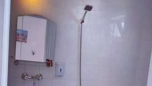 A small bathroom with a sink, toilet, and shower. - Pasha Hotel (Fethiye)