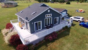 A two-story house with a covered porch, a satellite dish, and a fenced yard. - Water View Cottage With A/C In Quiet Location, Close To Amazing Beaches (Kensington)