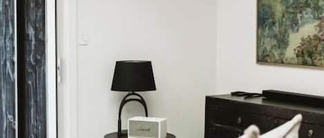 Una sala de estar moderna con un sofá blanco, una mesa de centro negra, una mesita de noche con una lámpara, un mueble negro y una cabeza de venado montada en la pared.