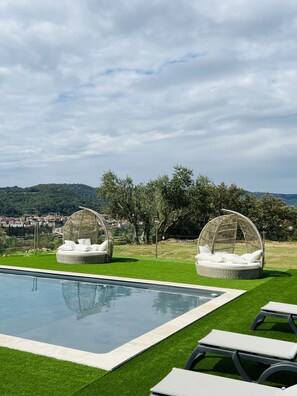 A poolside area with two wicker cabanas and a pool. - Gîtes 3 chambres -Piscine -Vue sur la vallée de l'Orb (Cessenon sur Orb)