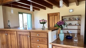 Una cocina con armarios de madera, una encimera y lámparas colgantes.