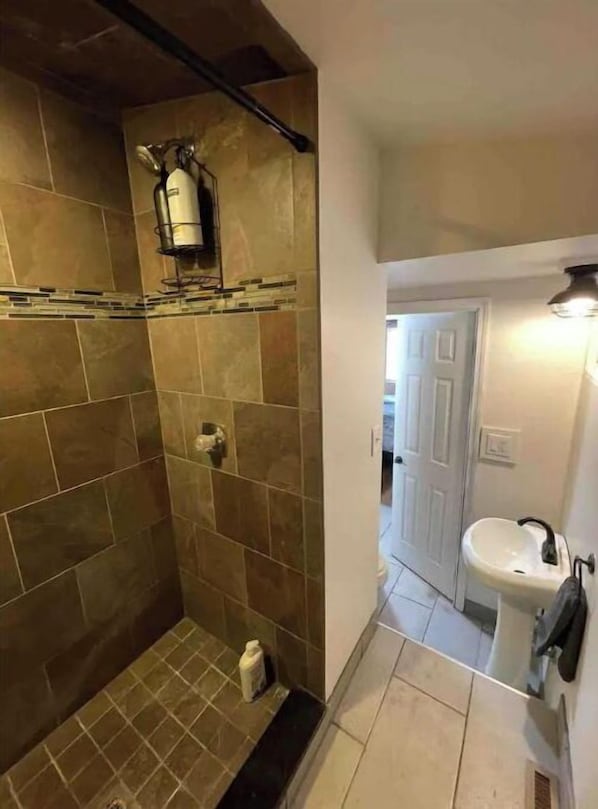 A bathroom with a shower, a sink, and a toilet.